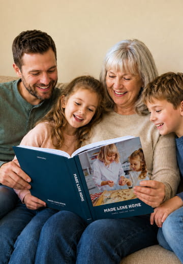 Family of five reading a navy Made Like Home cookbook on the sofa